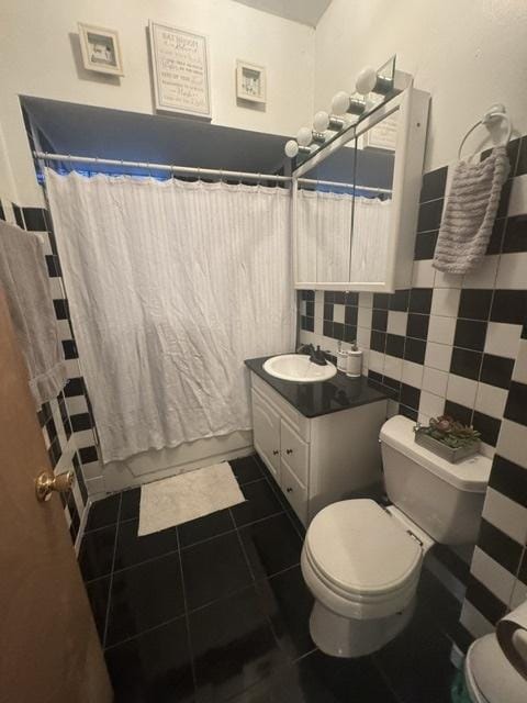 bathroom with vanity, tile patterned flooring, tile walls, and toilet