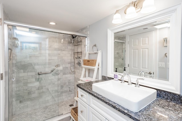 bathroom with a shower with door and vanity