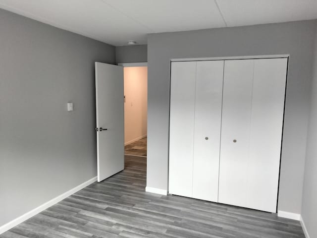 unfurnished bedroom with a closet and hardwood / wood-style flooring