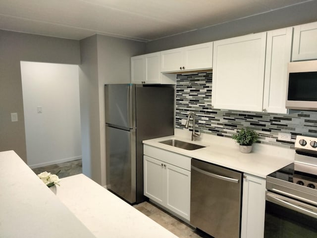 kitchen featuring sink, white cabinetry, backsplash, and stainless steel appliances