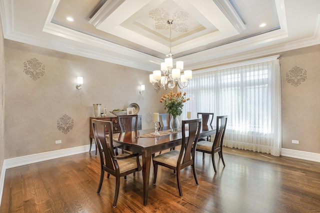 dining space with a raised ceiling, a notable chandelier, ornamental molding, and dark hardwood / wood-style floors