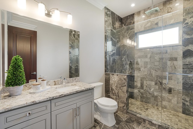 bathroom featuring a shower with shower door, toilet, vanity, and crown molding