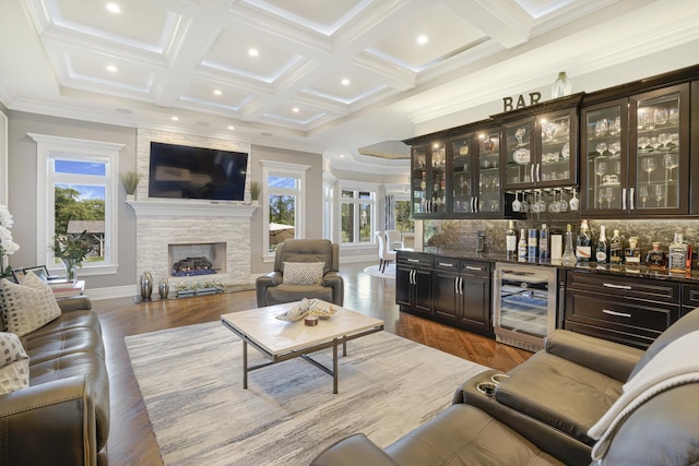 bar featuring backsplash, a fireplace, crown molding, dark brown cabinetry, and beverage cooler