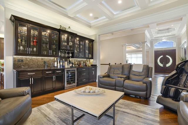 bar featuring coffered ceiling, backsplash, dark brown cabinets, wine cooler, and crown molding