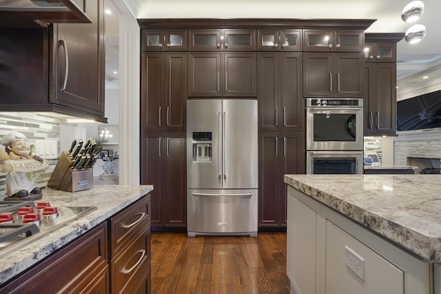 kitchen featuring light stone countertops, backsplash, dark hardwood / wood-style flooring, and stainless steel appliances