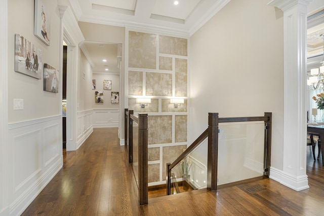 corridor with coffered ceiling, decorative columns, dark wood-type flooring, ornamental molding, and beam ceiling