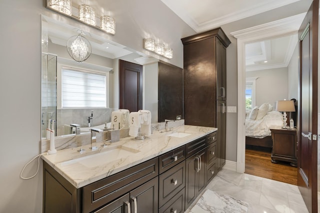 bathroom with vanity, crown molding, and a chandelier