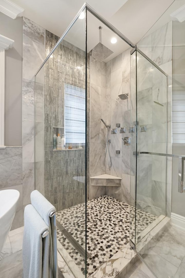 bathroom featuring tile walls, a shower with door, and crown molding