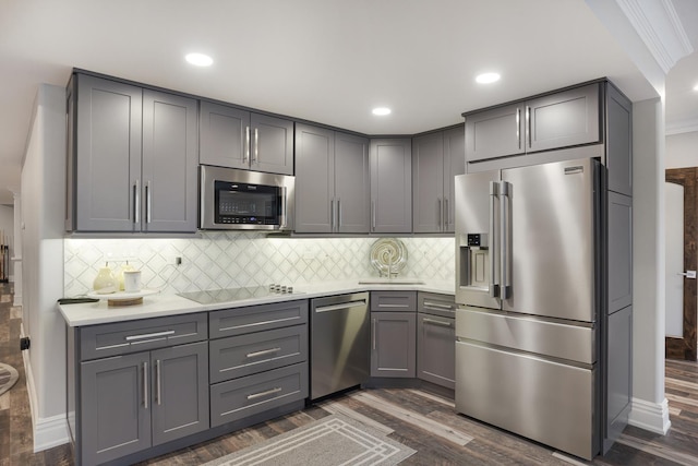 kitchen with stainless steel appliances, decorative backsplash, dark hardwood / wood-style flooring, and gray cabinets