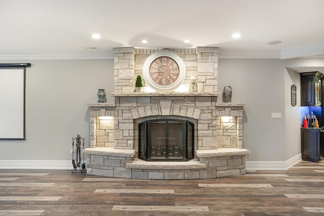 details featuring hardwood / wood-style flooring, crown molding, and a fireplace