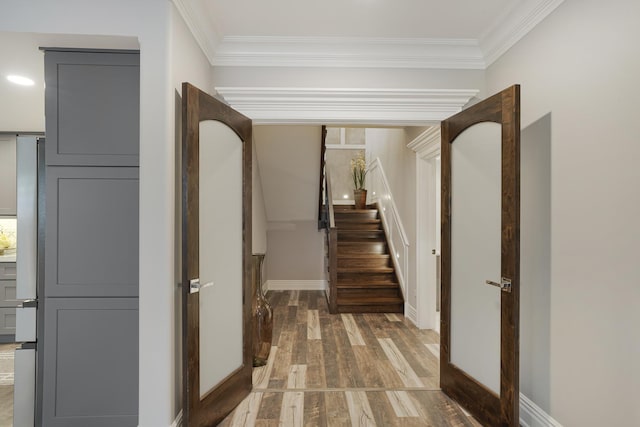 hall with dark wood-type flooring and ornamental molding