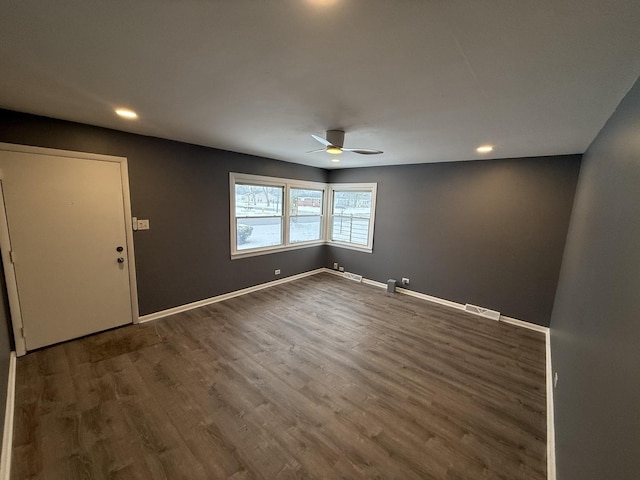 empty room featuring ceiling fan and dark hardwood / wood-style floors