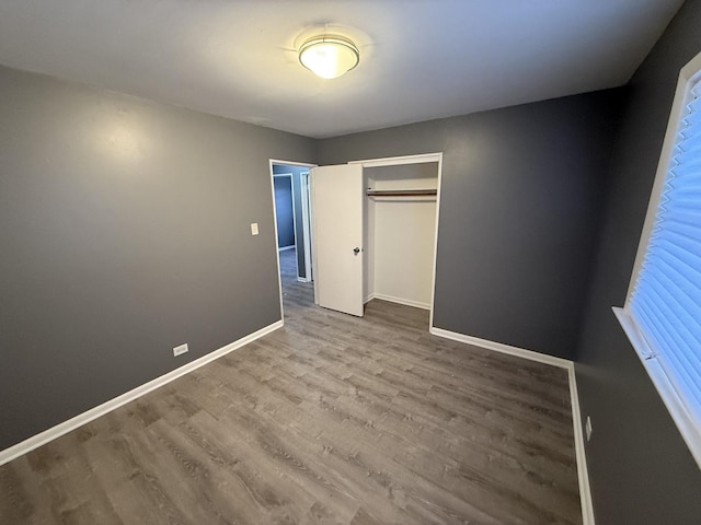 unfurnished bedroom with hardwood / wood-style floors and a closet