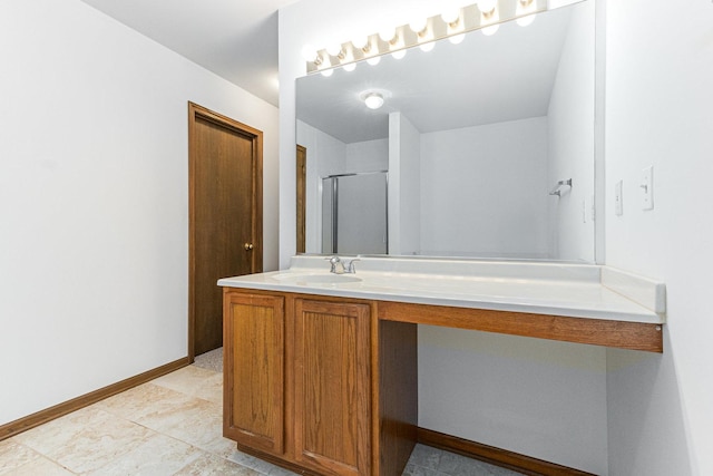 full bathroom featuring vanity, a shower with shower door, and baseboards