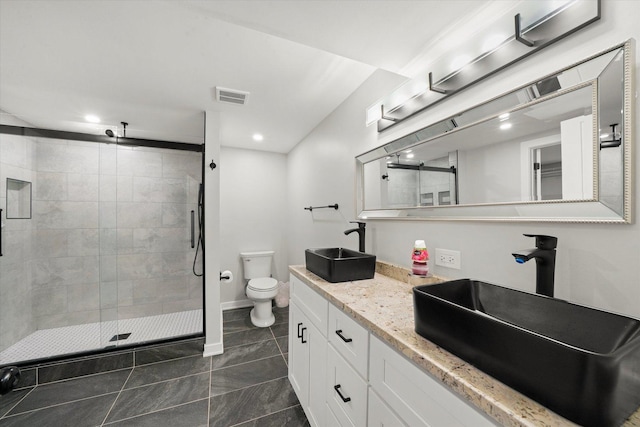 bathroom featuring toilet, a shower with door, vanity, and tile patterned flooring