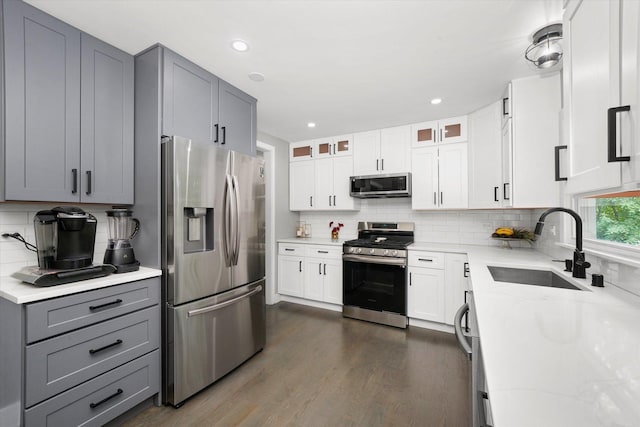 kitchen featuring sink, light stone countertops, gray cabinetry, stainless steel appliances, and white cabinets