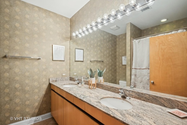 bathroom featuring toilet, vanity, and tile patterned flooring