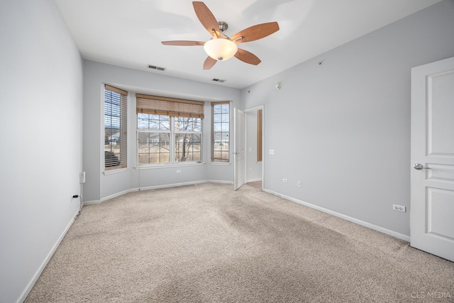 empty room with ceiling fan and light carpet