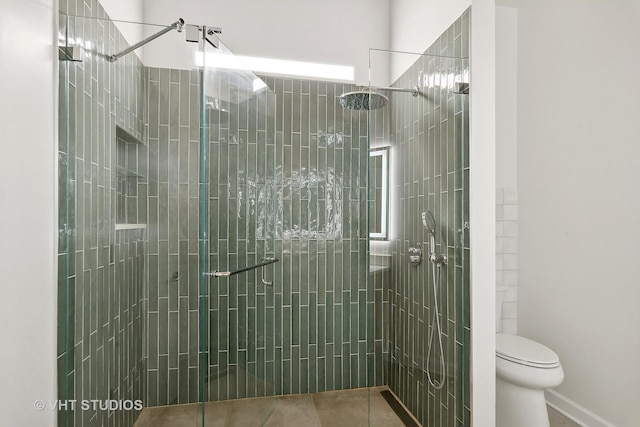 bathroom featuring an enclosed shower, tile patterned flooring, and toilet