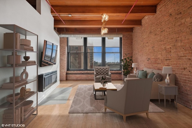 living room with brick wall, beam ceiling, a high ceiling, and light wood-type flooring