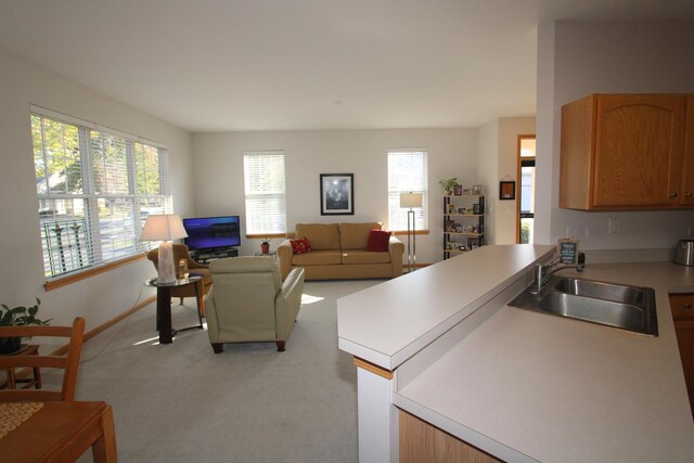 kitchen with pendant lighting, white appliances, sink, kitchen peninsula, and a notable chandelier