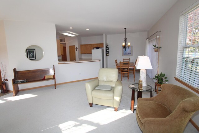 carpeted living room featuring a notable chandelier