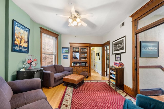 living room featuring light wood-type flooring and ceiling fan