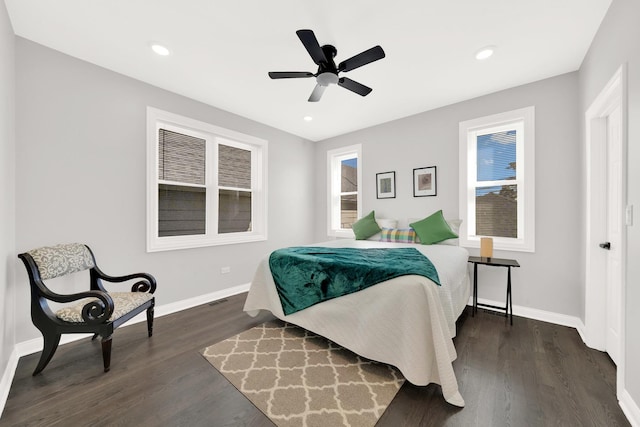 bedroom with ceiling fan, dark hardwood / wood-style floors, and multiple windows