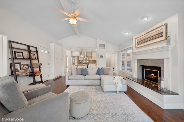 living room featuring ceiling fan, dark hardwood / wood-style floors, and vaulted ceiling with beams