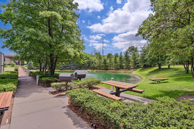 view of community featuring a water view and a lawn