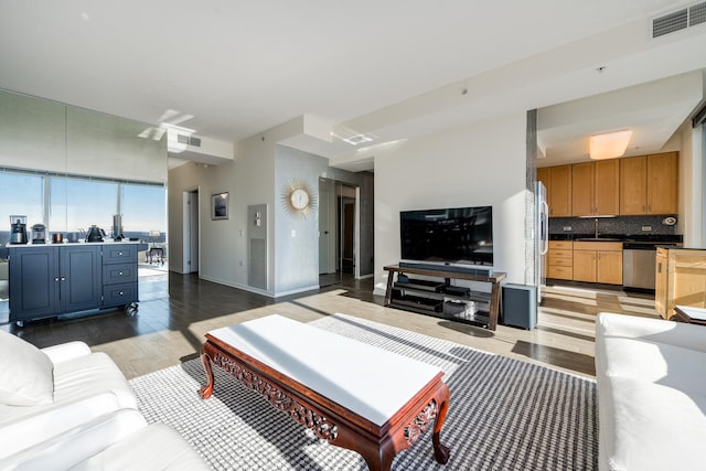 living room featuring sink and light hardwood / wood-style flooring