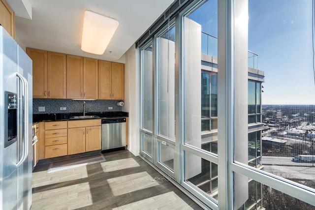 kitchen featuring tasteful backsplash, appliances with stainless steel finishes, sink, and hardwood / wood-style floors