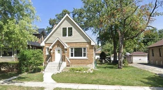 view of front facade with a garage, an outdoor structure, and a front lawn