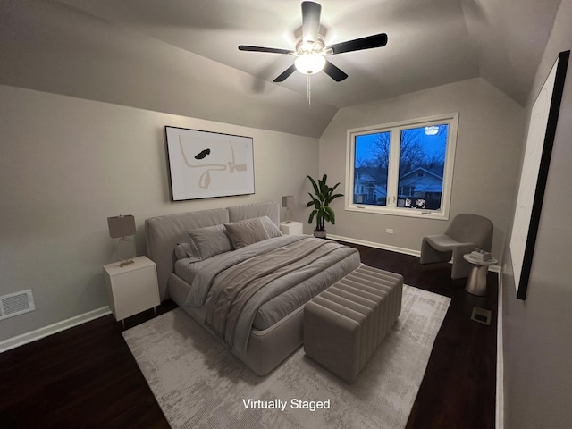 bedroom featuring dark hardwood / wood-style flooring, vaulted ceiling, and ceiling fan