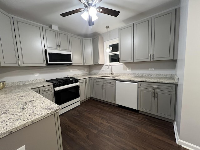 kitchen featuring sink, gas stove, gray cabinetry, dark hardwood / wood-style flooring, and dishwasher