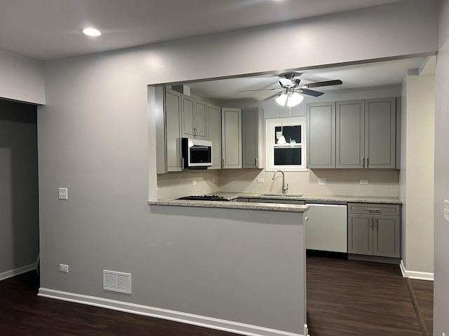 kitchen featuring tasteful backsplash, appliances with stainless steel finishes, sink, and kitchen peninsula