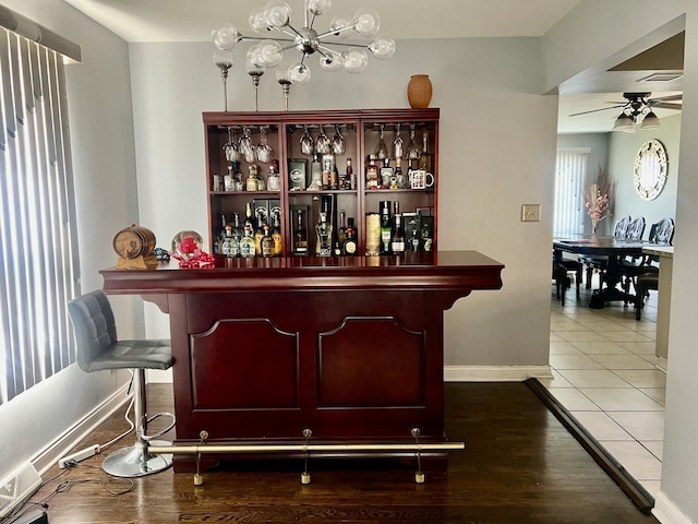 bar featuring ceiling fan and tile patterned flooring