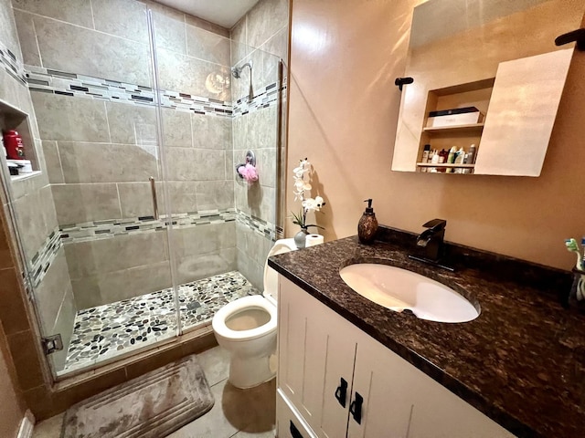 bathroom featuring toilet, walk in shower, vanity, and tile patterned flooring