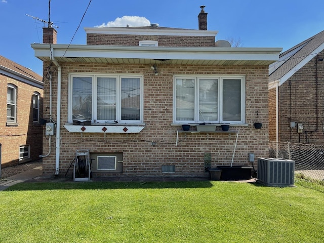 back of property with cooling unit and a lawn