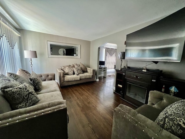 living room with dark wood-type flooring and a fireplace