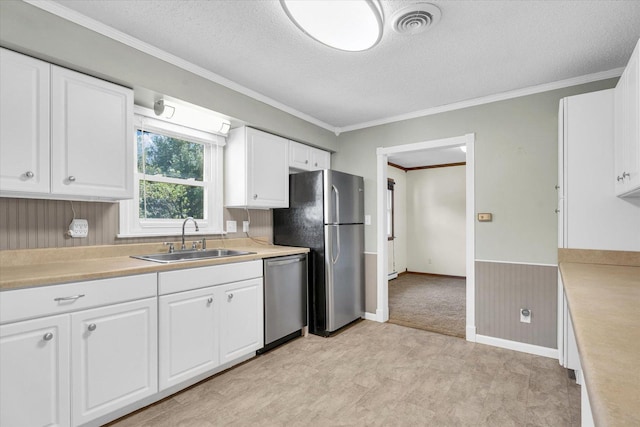 kitchen with sink, white cabinetry, appliances with stainless steel finishes, and a textured ceiling