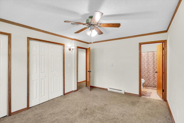 unfurnished bedroom featuring baseboard heating, a textured ceiling, ensuite bath, ceiling fan, and light colored carpet