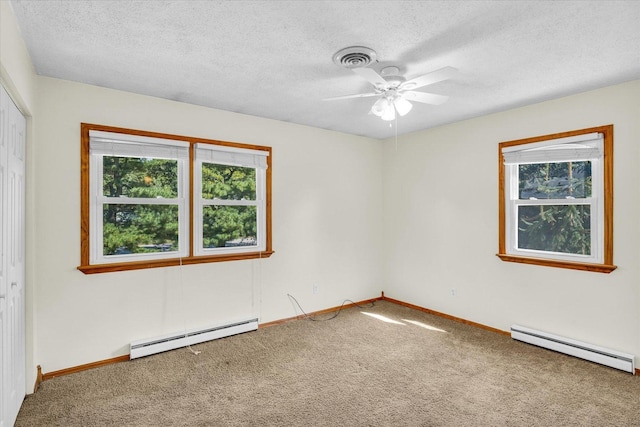 spare room with a textured ceiling, baseboard heating, and carpet floors