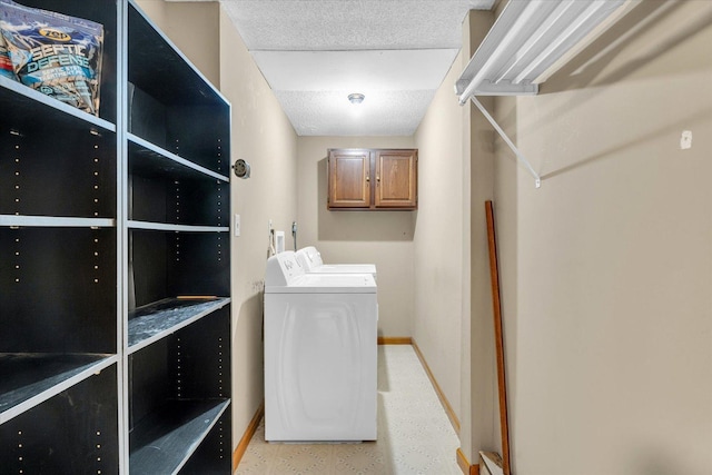 laundry room featuring washer and clothes dryer and cabinets