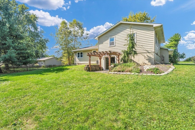 back of house featuring a pergola and a lawn