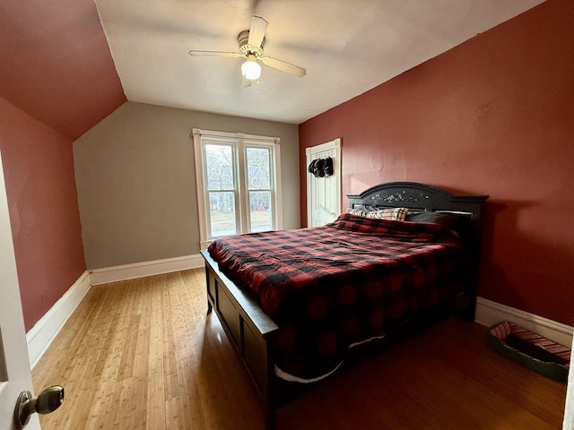 bedroom with ceiling fan, lofted ceiling, and light wood-type flooring