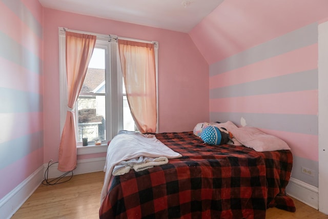 bedroom with lofted ceiling and light hardwood / wood-style floors