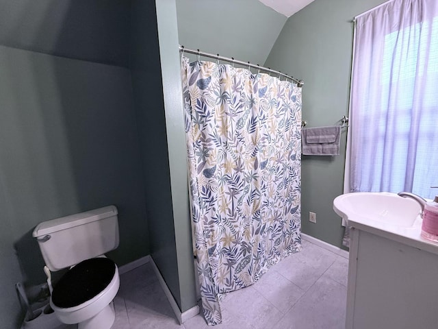 bathroom with vanity, vaulted ceiling, tile patterned floors, and toilet