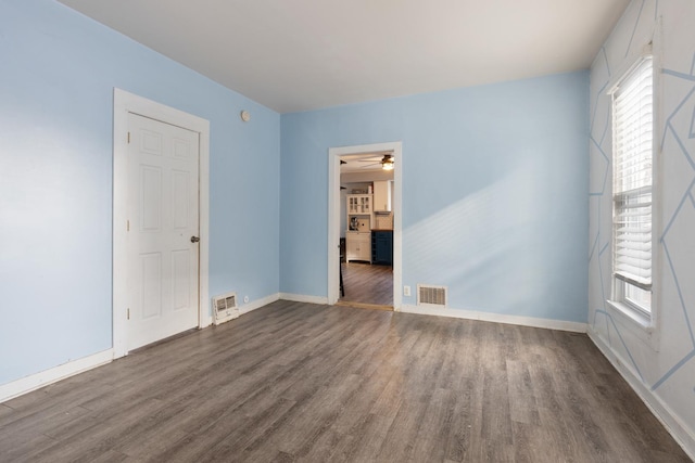 unfurnished room featuring plenty of natural light and dark hardwood / wood-style flooring