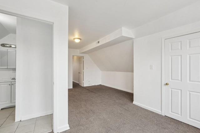 additional living space featuring lofted ceiling and light colored carpet